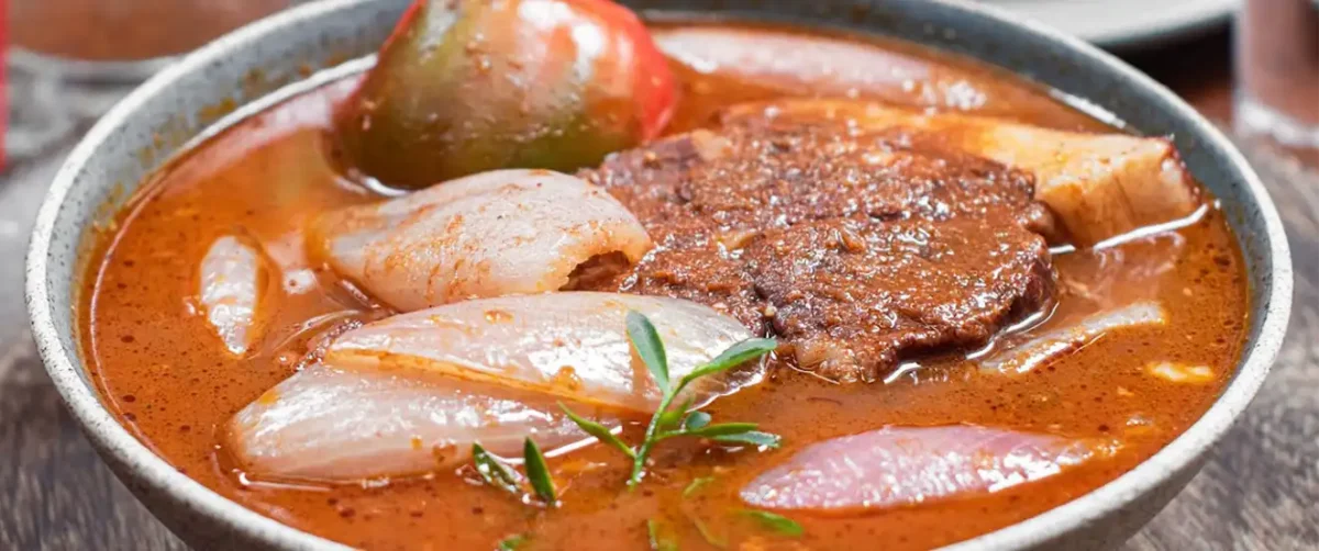 Rustic Peruvian adobo arequipeño beef stew with onions in rich red broth.