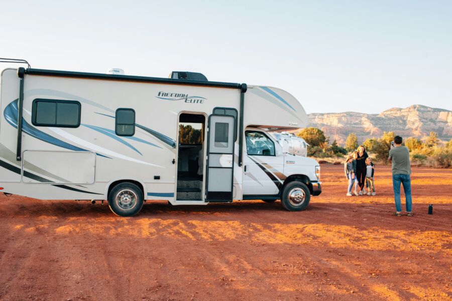 White Freedom Elite RV is parked in a vast red desert 