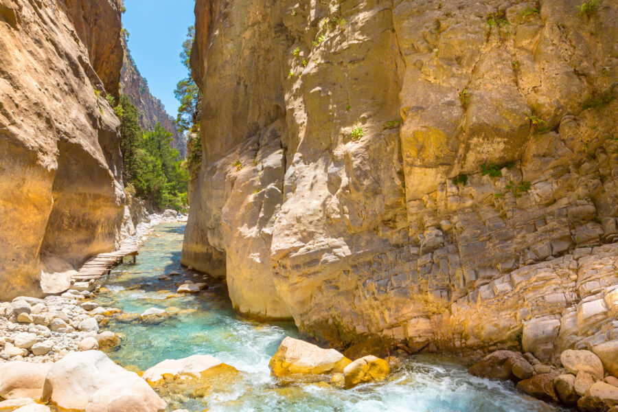 Scenic view of the famous Samaria Gorge in Crete, Greece, showcasing towering cliffs and lush greenery