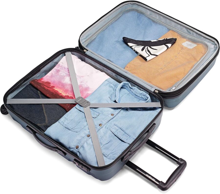 Open Samsonite Omni PC suitcase displaying packed clothes, with a shirt resting on top of the neatly arranged items.