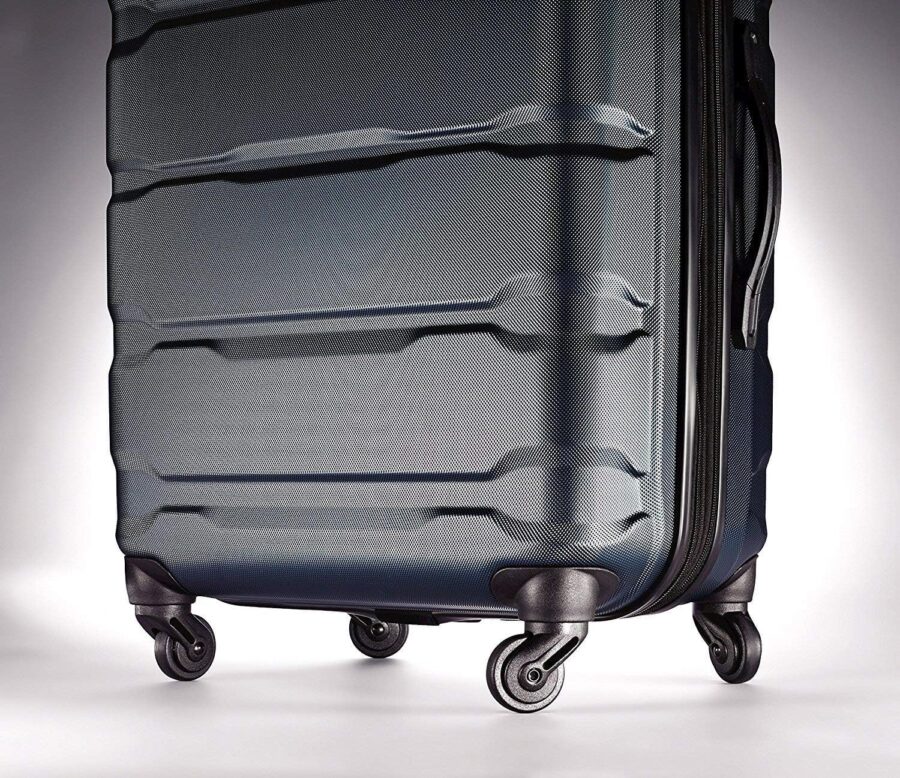 Large black Samsonite Omni PC hardside suitcase with wheels on a white background.