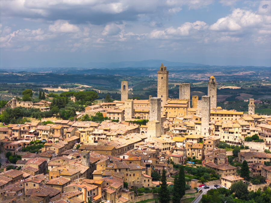 Aerial view of San Gimignano's medieval towers at sunset, surrounded by the picturesque Tuscan countryside