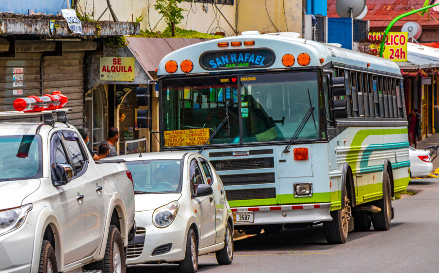 San José, Costa Rica, bustling with colorful buses and crowds of people, illustrating the city's vibrant urban atmosphere
