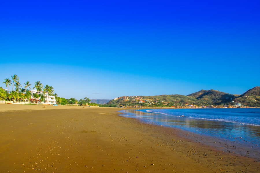 Beautiful Playa Maderas in San Juan del Sur, showcasing soft sandy beach, clear blue water, and vibrant tropical scenery