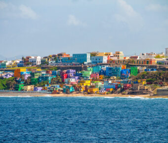 Vibrant houses line the hillside, offering a stunning view of the beach in San Juan, Puerto Rico