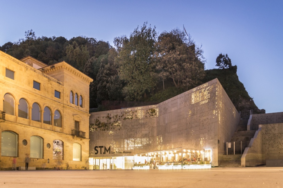 San Sebastiáns San Telmo Museum at dusk with historic façade and modern perforated extension.