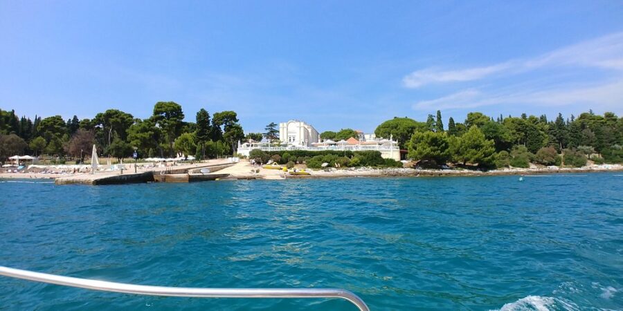 Scenic view of the sea from a boat near Santa Caterina Island, Rovinj, Croatia, with clear blue waters and distant land.