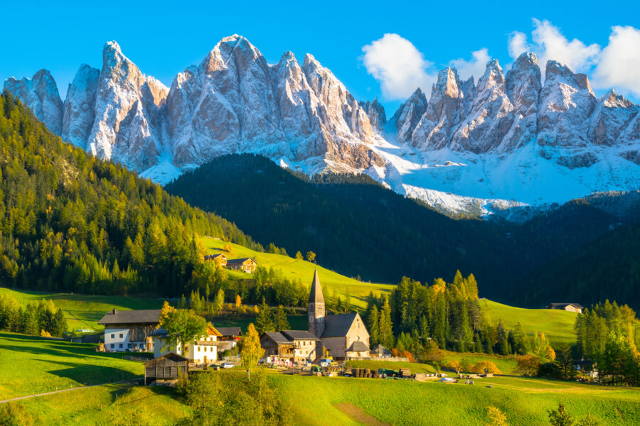 Scenic sunset illuminating Santa Maddalena village in Val di Funes, with the majestic Dolomites in the background, Italy.
