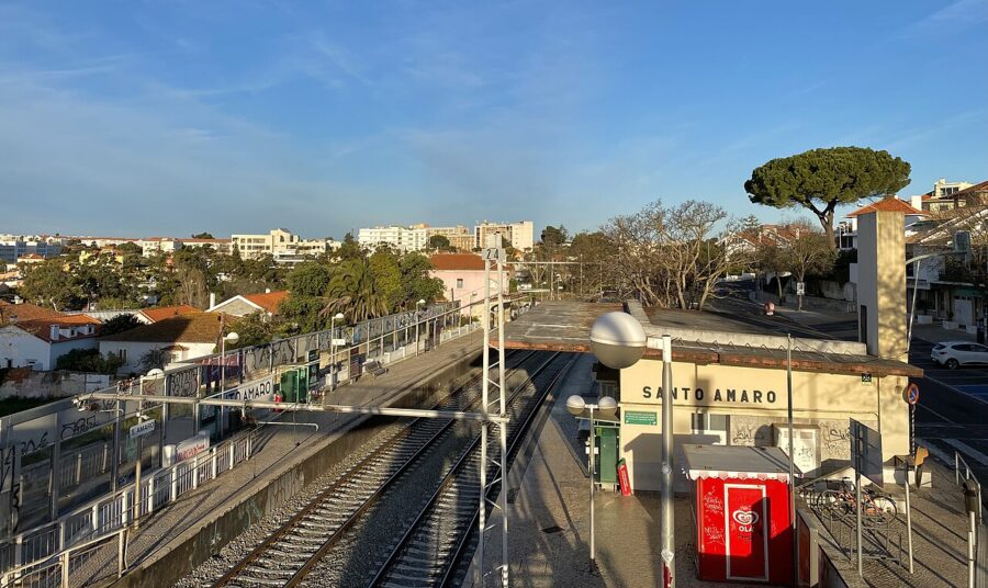 The train station in Santo Amaro, Portugal, highlighted by a red stop sign, indicating a halt for incoming trains.
