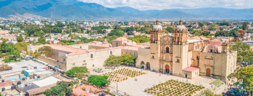 Historic Santo Domingo Old Monastery in Oaxaca, Mexico, showcasing colonial architecture and lush surrounding gardens.
