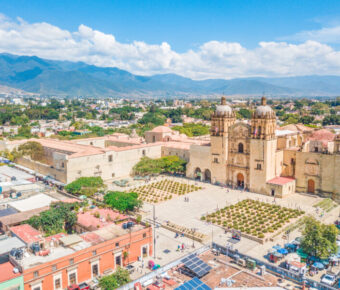 Historic Santo Domingo Old Monastery in Oaxaca, Mexico, showcasing colonial architecture and lush surrounding gardens.