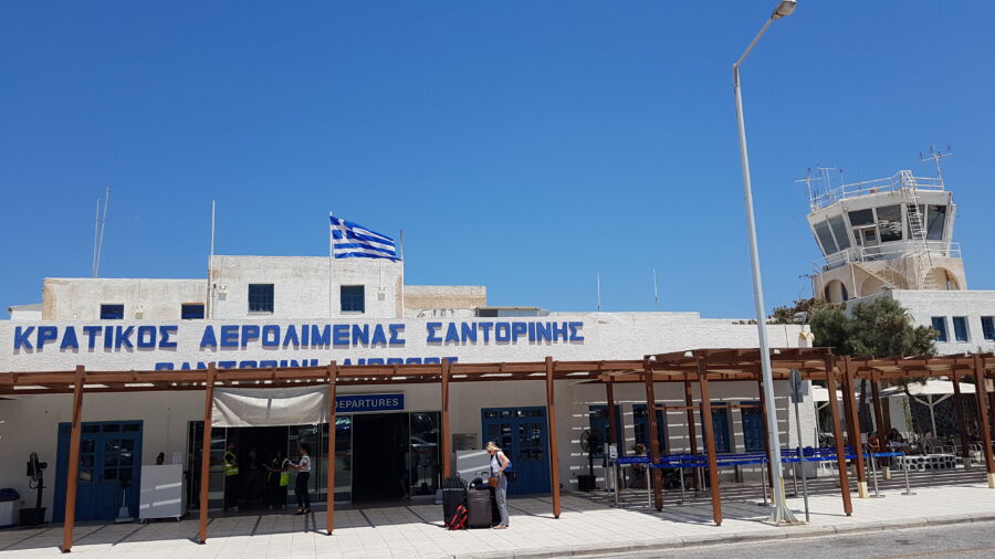 Santorini Airport building featuring a prominent white roof against a clear blue sky.
