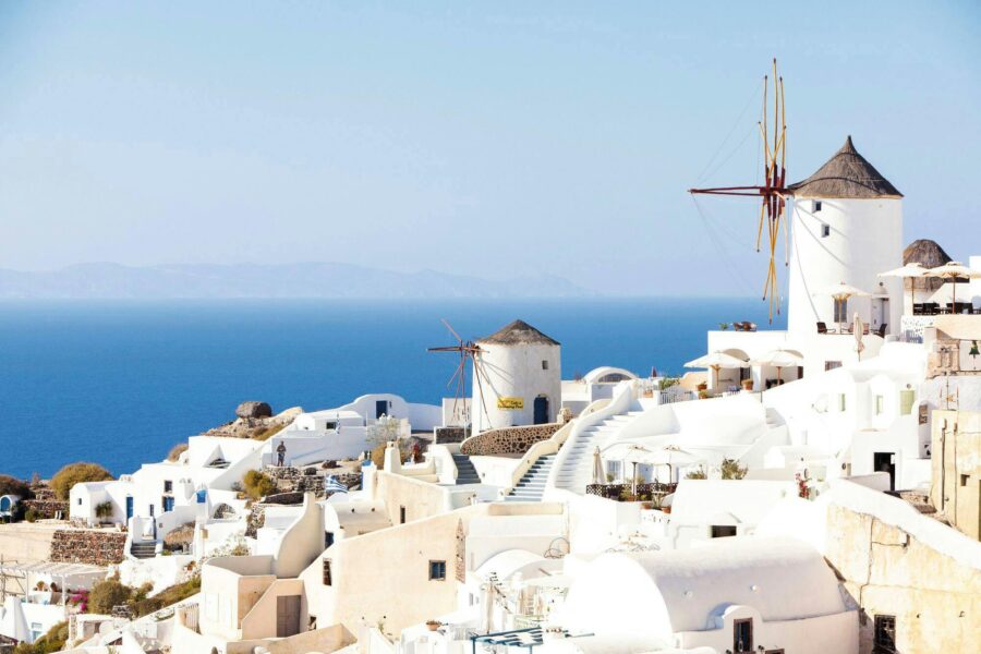 Santorini windmills and whitewashed architecture overlooking the Aegean Sea in Greece.
