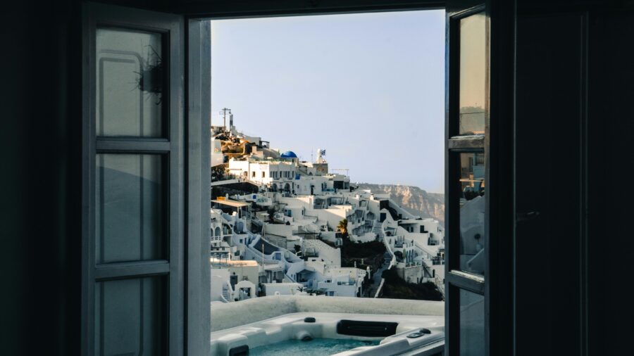 Idyllic Greek island doorway view with traditional white buildings and a relaxing spa.
