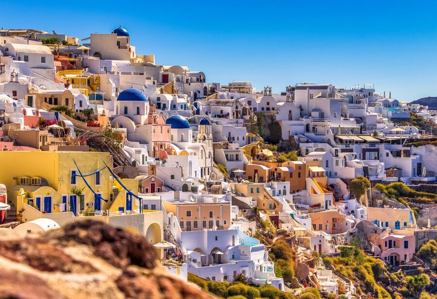Santorini’s whitewashed architecture, blue domes, and vibrant colors on a picturesque Greek island.