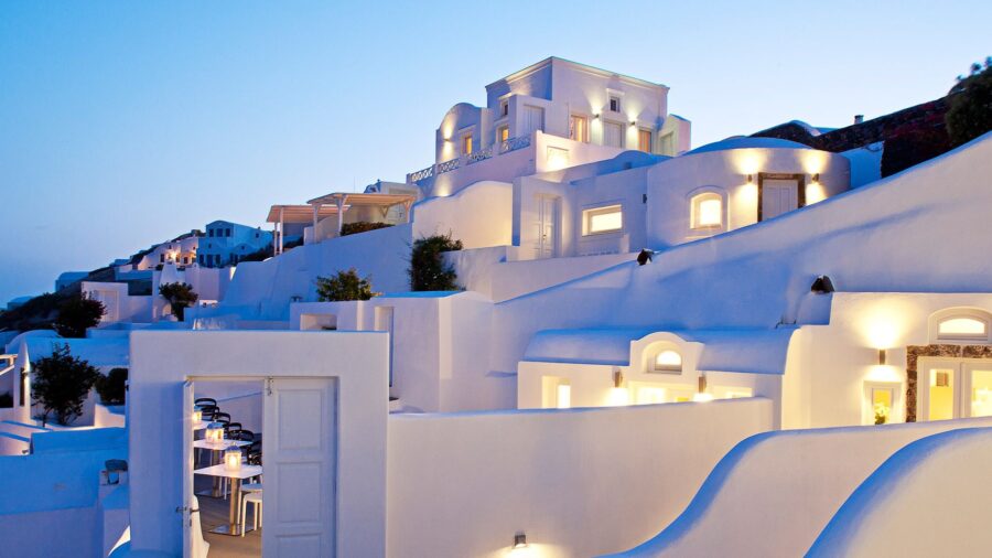 Santorini at twilight: white-washed buildings, Cycladic architecture, dining with breathtaking views.
