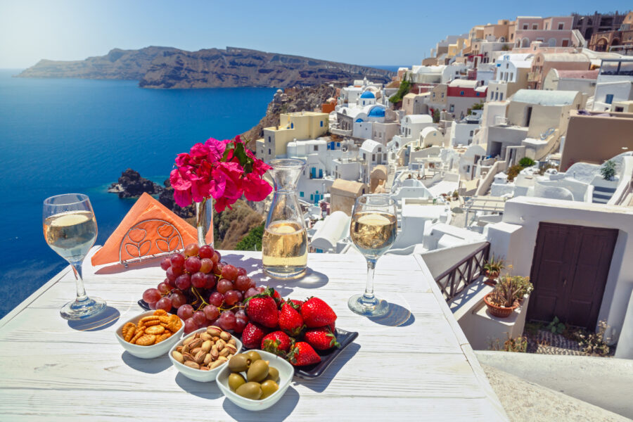 Scenic view of Santorini showcasing local wine and traditional dishes against a backdrop of blue skies and white buildings
