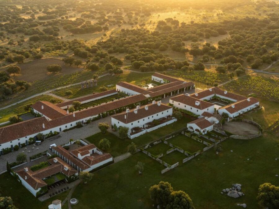 Aerial view of São Lourenço do Barrocal estate at sunset, showcasing lush landscapes and warm, glowing skies.
