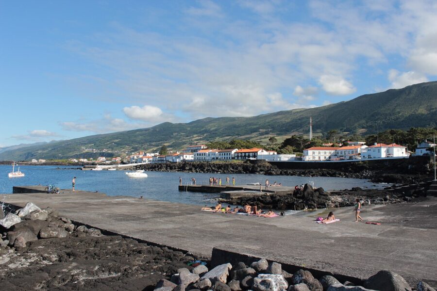 Scenic view of São Roque do Pico, featuring a body of water with people enjoying activities on its surface.
