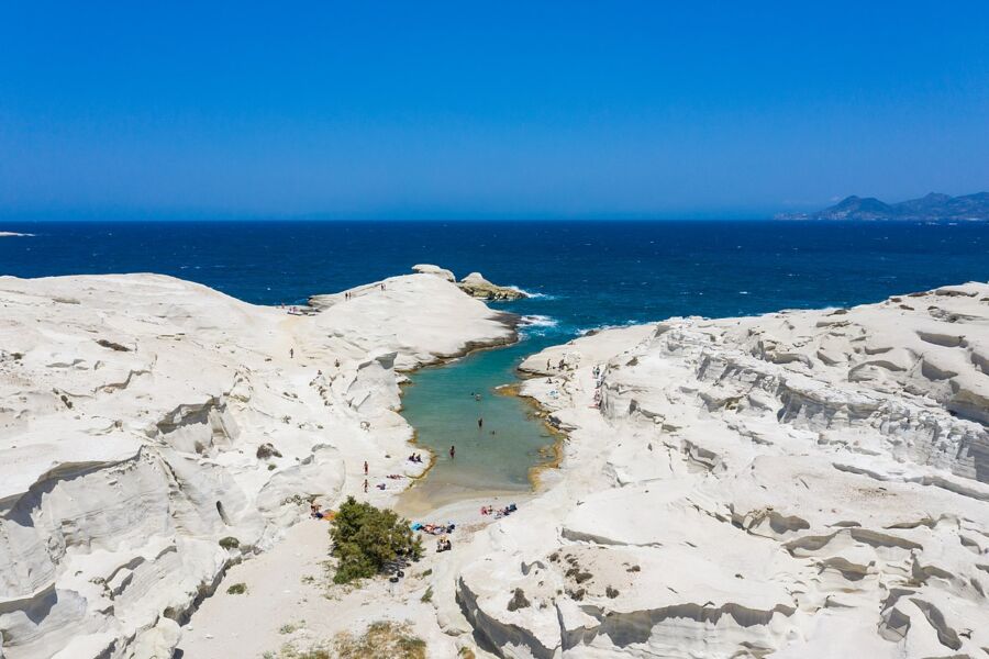 Aerial view of Sarakiniko Beach, showcasing the sandy shore and turquoise waters below.
