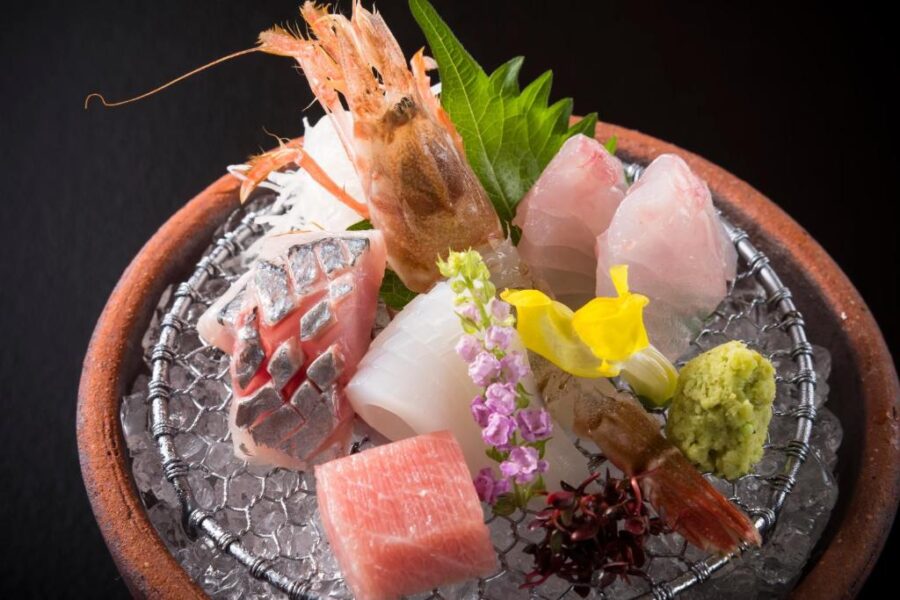 Gourmet Japanese sashimi platter on crushed ice with shrimp, fatty tuna, squid and wasabi.