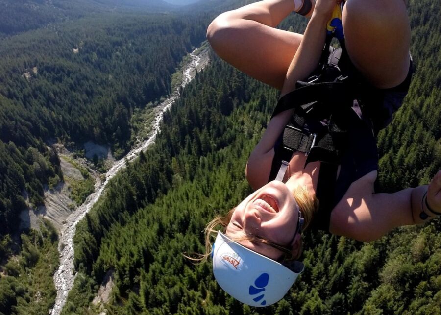Woman enjoys the thrill of ziplining down a mountain at the Sasquatch Zipline in Whistler, Canada.