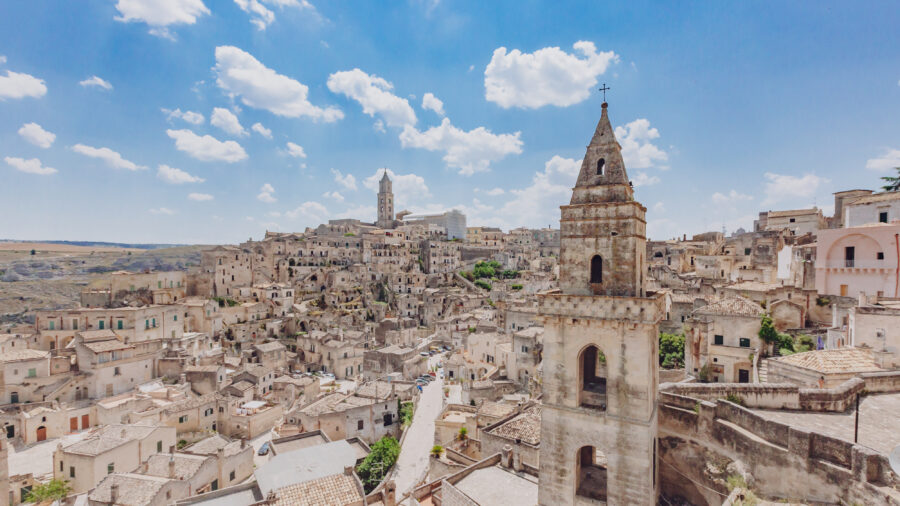 Scenic view of the Sassi of Matera, Italy, showcasing ancient cave dwellings carved into limestone cliffs.