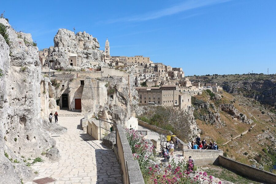 Panoramic view from a hilltop in Matera, showcasing Sasso Caveoso's ancient stone buildings and surrounding landscape.
