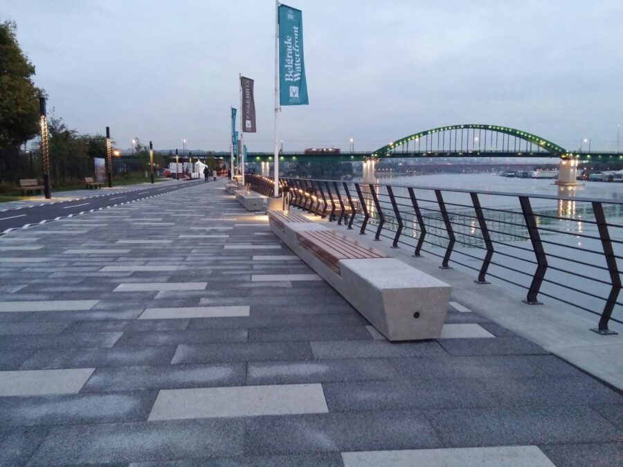 Bench on the sidewalk beside the river in Savamala, Stari Grad, Belgrade, with calm water flowing nearby.