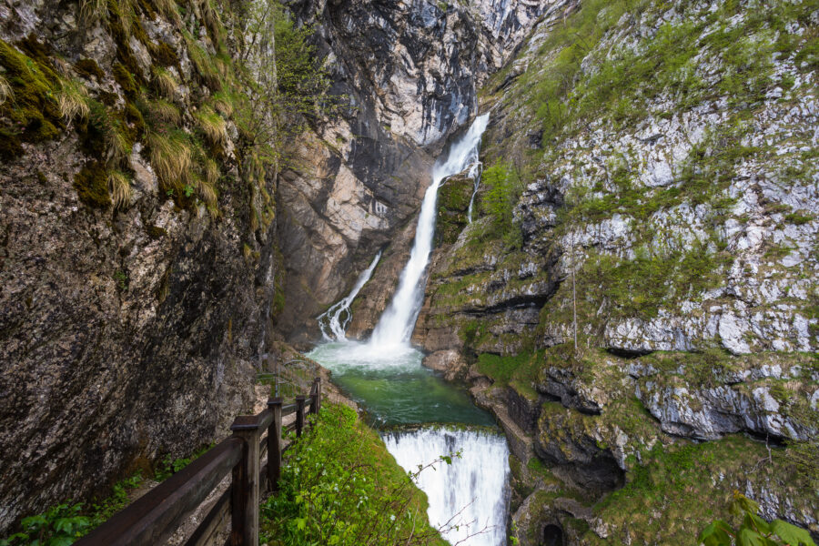 Savica waterfall cascading down rocky cliffs in Triglav National Park, surrounded by lush greenery and serene natural beauty