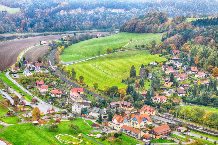 Scenic view of Rathen village in Saxon Switzerland National Park, showcasing vibrant autumn colors from Bastei viewpoint.
