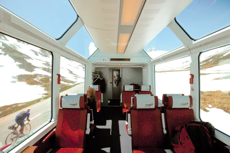 Modern train interior with plush seats, panoramic windows, and stunning scenic views.