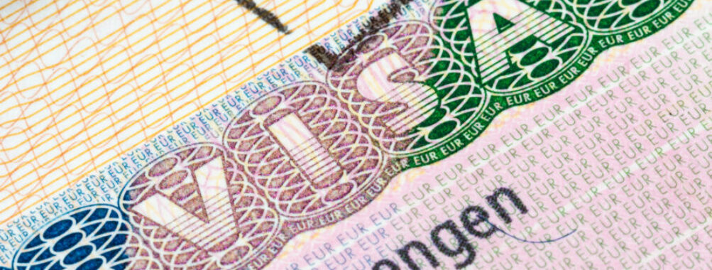 Detailed view of a Schengen visa in a passport, highlighting the unique design elements of a visa stamp