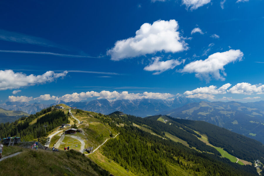 Panoramic view from the summit of Schmittenhohe mountain, showcasing snow-capped peaks and lush valleys in Austria