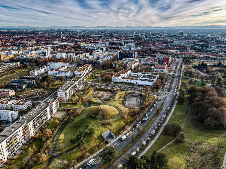 Panoramic view of Schwabing-West and Munich's city center, showcasing urban architecture and greenery to the south.

