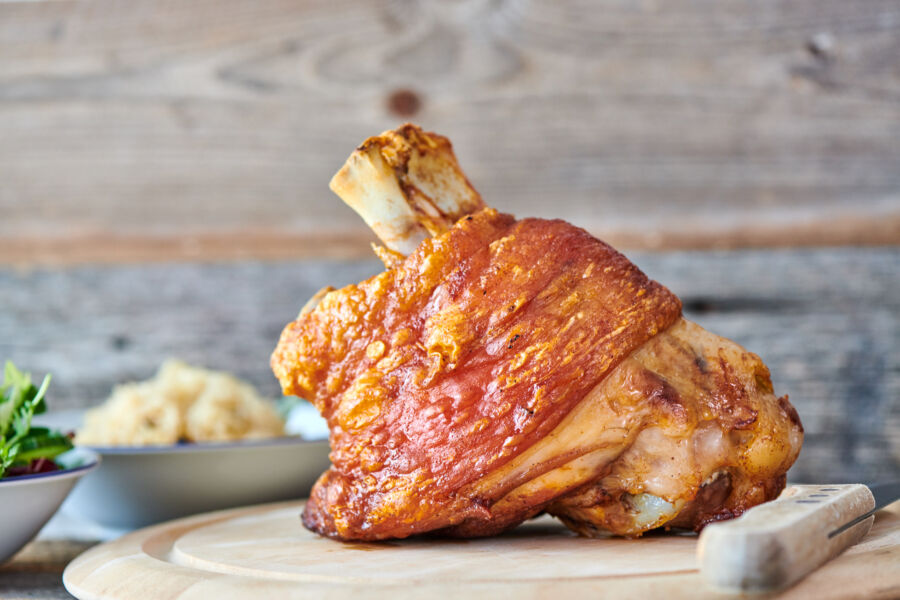 Close-up of slow-roasted Schweinshaxe, a traditional German pork knuckle, showcasing its crispy skin and tender meat