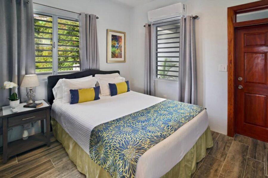 Interior of Scotland Villa 1's bedroom, showcasing a bed, a window, and a door in St Thomas, U.S. Virgin Islands.