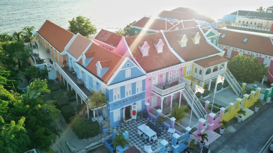 Colorful beach houses at Scuba Lodge & Suites in Willemstad, Curacao, with the ocean in the background.
