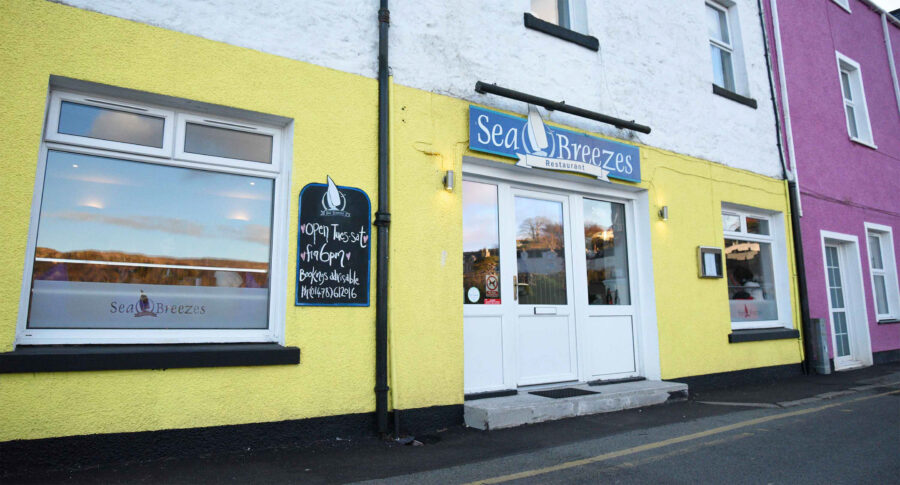 Vibrant Sea Breezes restaurant facade with coastal theme and bright yellow exterior.