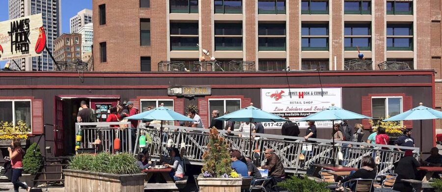 James Hook & Co. bustling seafood restaurant with outdoor dining, urban skyline backdrop.