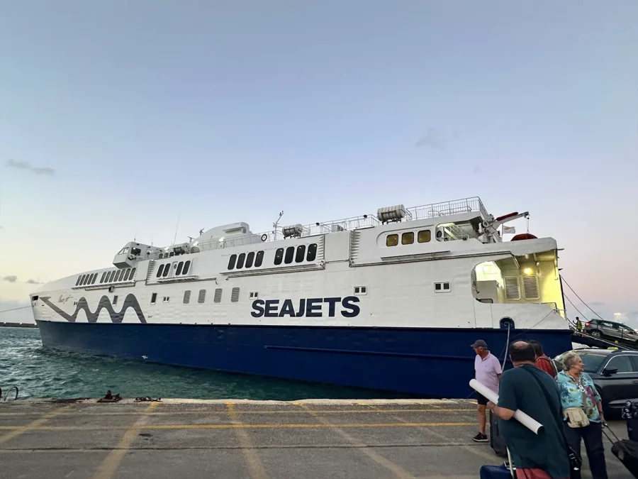 Seajets ferry docked in Greek island port with passengers and vehicles boarding at sunset.