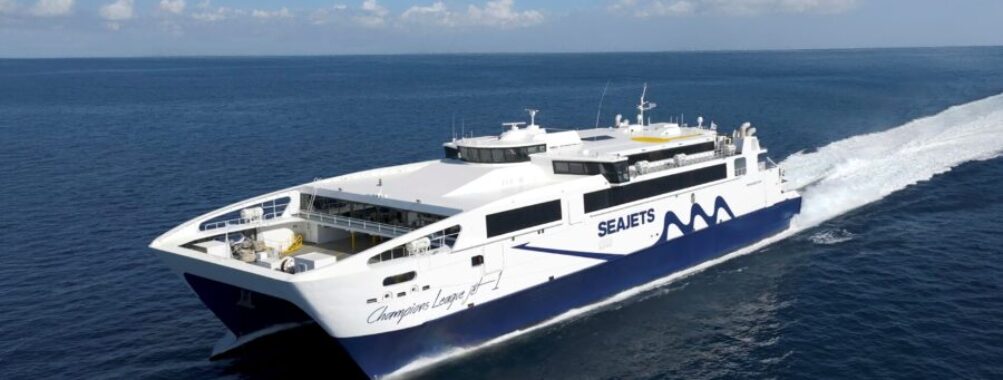 High-speed Seajets Champions League 1 catamaran ferry cruising on calm blue Aegean Sea.