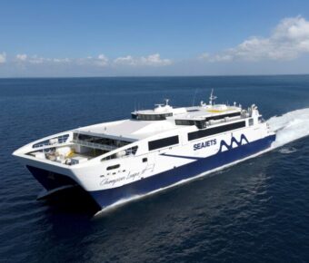 High-speed Seajets Champions League 1 catamaran ferry cruising on calm blue Aegean Sea.