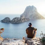 Tourist in a cliff overviewing the beach in Ibiza