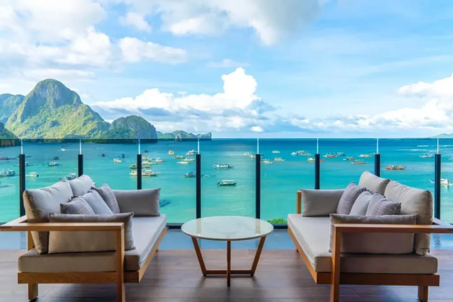El Nido luxury seaside deck with ocean view, lounge seating, and limestone island scenery.