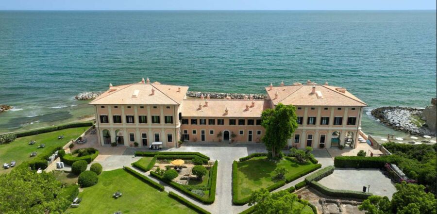 Elegant coastal mansion with classical architecture, lush gardens, and stunning sea views.