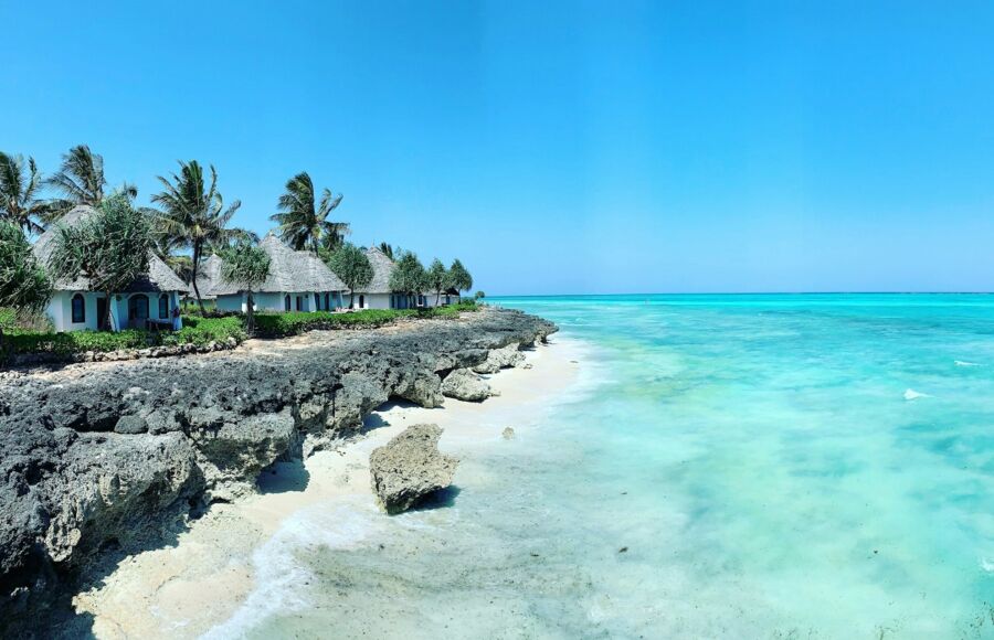 Serene tropical beach huts with swaying palms and vibrant turquoise waters invite relaxation.