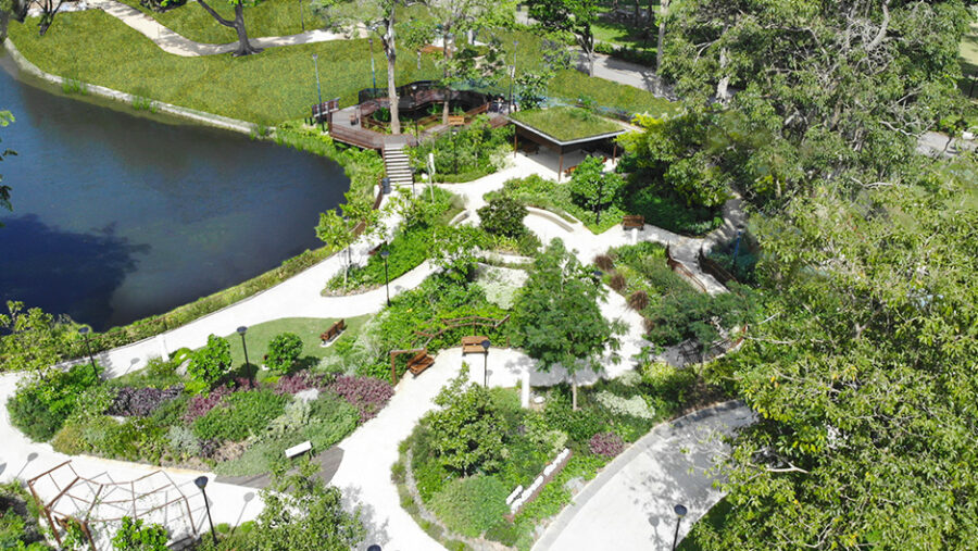 Tranquil park with pond, lush gardens, benches, pathways, observation deck, and pavilion.