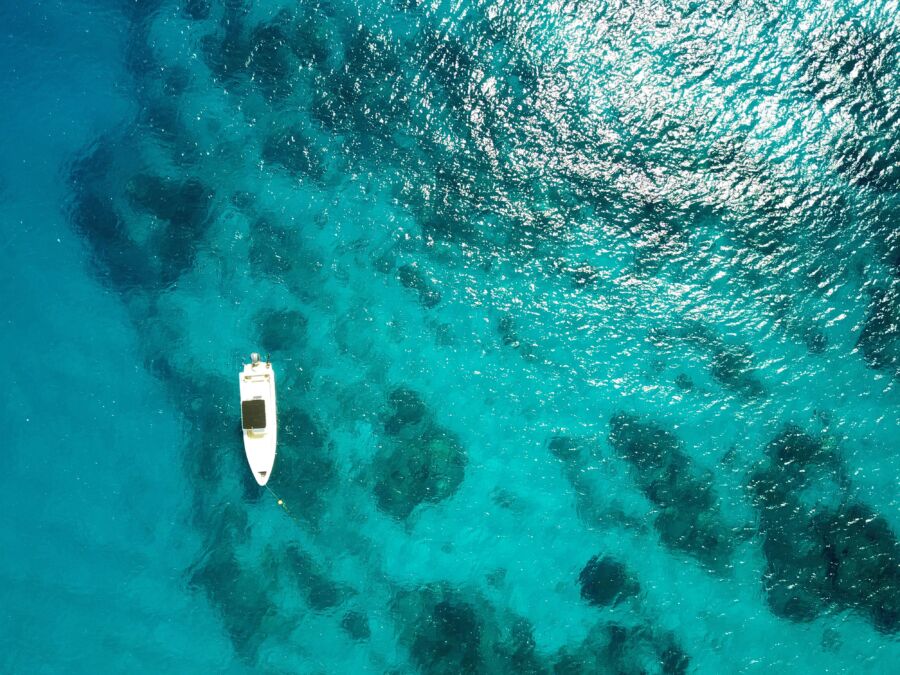 Aerial view of a white boat on turquoise water in Fiji
