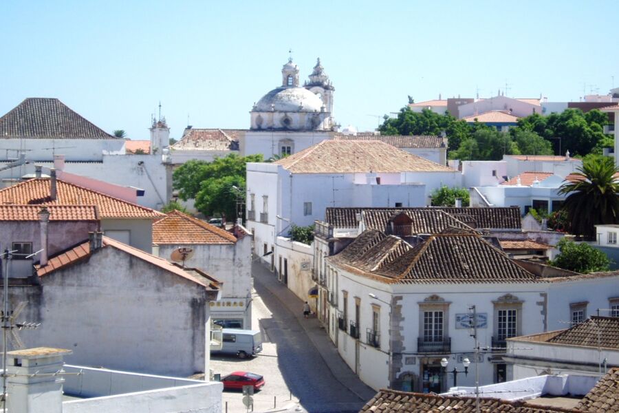 Charming Tavira historical town with white-washed buildings, terracotta roofs, and a central church dome.
